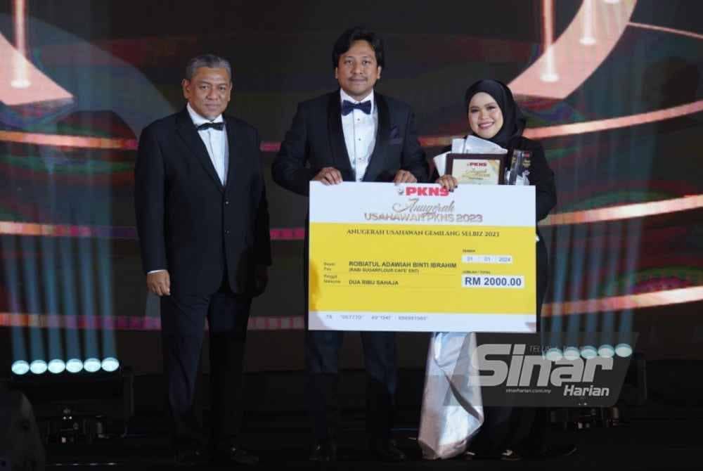 Halimi (tengah) menyampaikan Anugerah Usahawan Gemilang SELBIZ 2023 kepada Robiatul Adawiyyah Ibrahim (usahawan syarikat Rabi Sugarflour Cafe' Ent) pada Malam Anugerah Usahawan PKNS 2023 di Shah Alam pada Rabu. Foto Sinar Harian-MOHD HALIM ABDUL WAHID