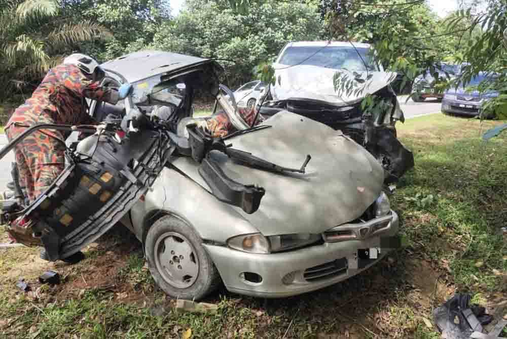 Anggota bomba membantu mengeluarkan mangsa tersepit dalam kereta Proton Wira.