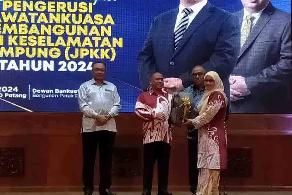 Saarani (dua dari kiri) menyampaikan kit JPKK kepada wakil pengerusi JPKK sempena Kursus Pemantapan Pengerusi JPKK di Dewan Banquet Bangunan Perak Darul Ridzuan di sini pada Khamis.