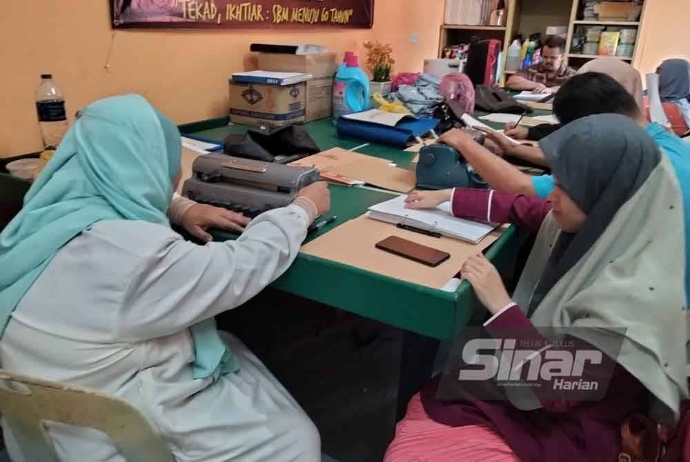 Raja Noor Hani (kanan) dan rakan-rakan belajar menggunakan Braille di Pusat Pertubuhan Orang Cacat Malaysia Cawangan Malaysia pada Jumaat.