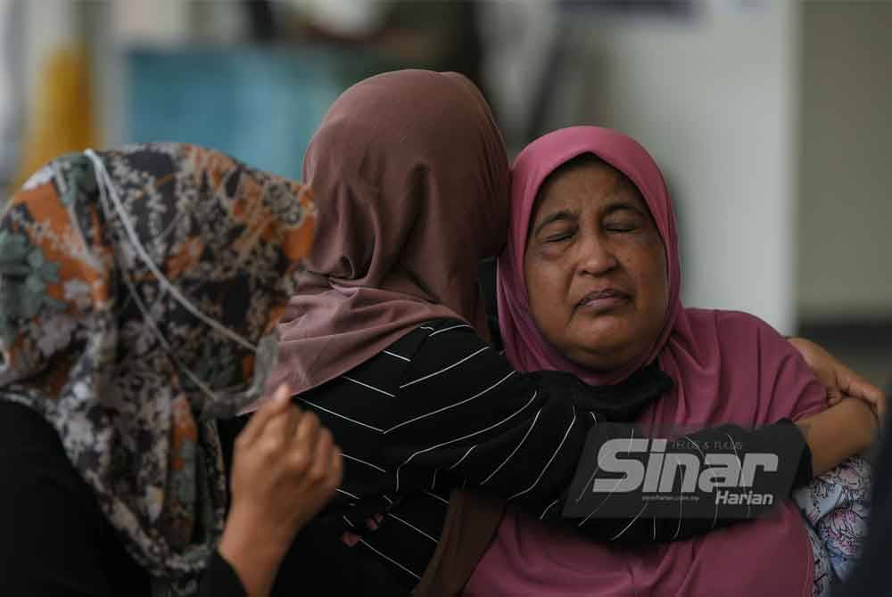Ruzita (kanan) tidak dapat menahan kesedihan selepas anaknya terlibat dalam kemalangan maut di Kilometer 77.5 Lebuhraya Utara Selatan arah utara dekat Gurun pada Jumaat. Foto Bernama