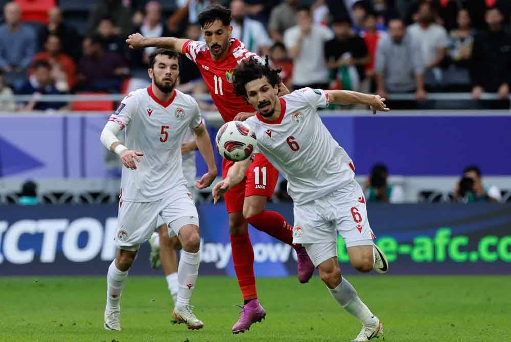 Pemain Jordan, Yazan al-Naimat bersaing dengan Vakhdat Khanonov semasa aksi suku akhir Piala Asia Qatar 2023 di Stadium Ahmad Bin Ali, Doha. - Foto AFP.