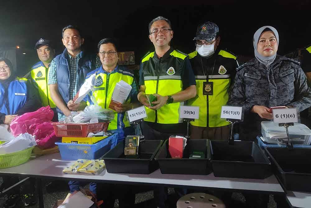 Mohd Fauzi (empat dari kanan) menunjukkan antara dokumen yang diperiksa dalam Operasi Bersepadu di Pasar Borong Selangor pada Sabtu.