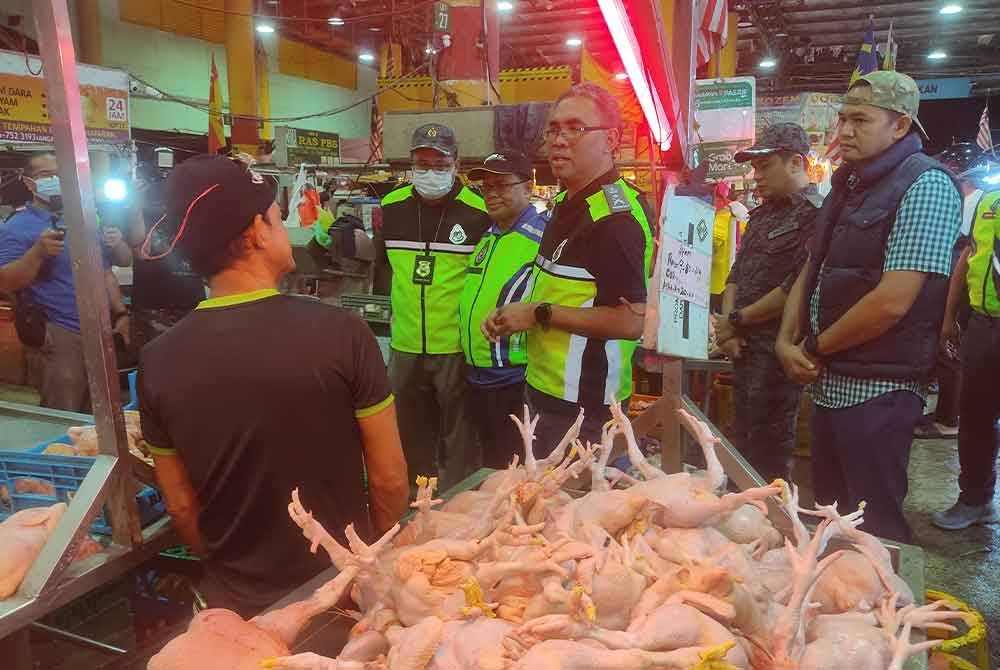 Mohd Fauzi (dua dari kiri) menjalankan pemeriksaan dengan diiringi Pengarah Imigresen Selangor, Khairrul Aminus Kamaruddin di Pasar Borong Selangor pada Sabtu.