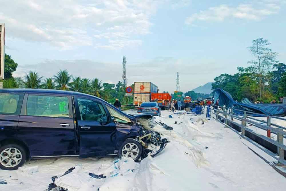 Laluan lebuh raya ditutupi gula selepas treler membawa muatan gula terbabit dalam nahas tujuh kenderaan.Foto Bomba Perak