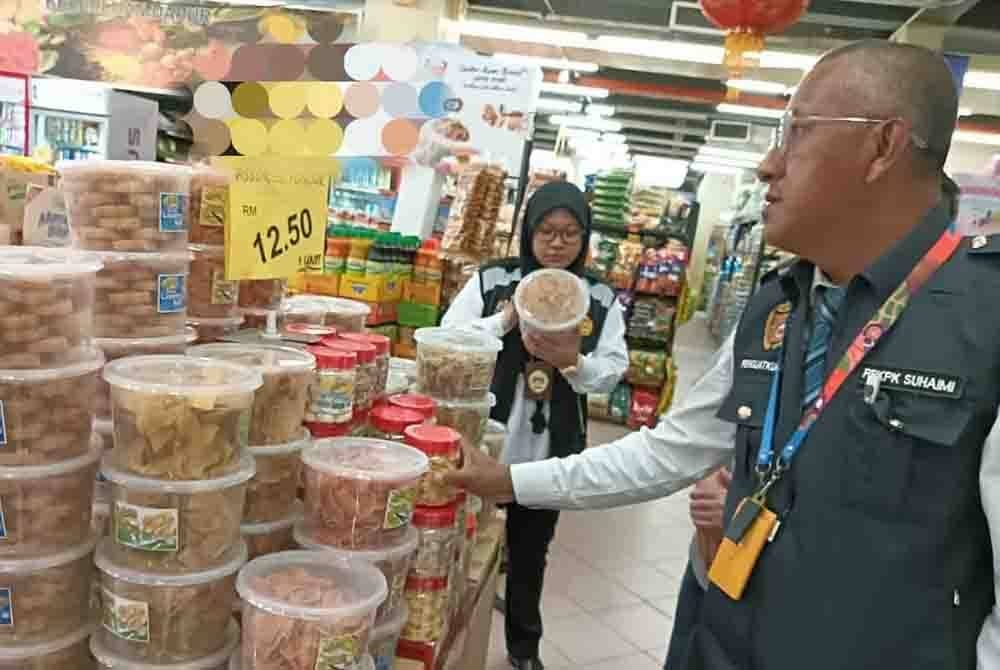 Anggota penguat kuasa JKNP melakukan pemeriksaan ke atas produk makanan yang dijual di sebuah pasar raya.