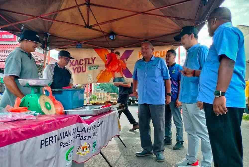 Nor Azhar (empat dari kiri) ketika melawat gerai jualan peserta di Pasar Tamu Masjid Tanah, pada Sabtu.