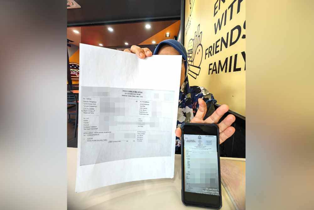 Yusnita menunjukkan notis saman yang diterima nya