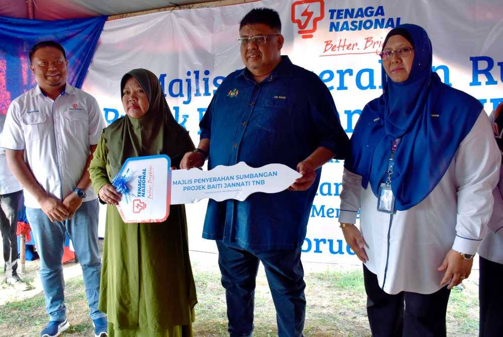 Ab Rauf (dua dari kanan) menyerahkan replika kunci rumah kepada penerima Rohani Karim (dua, kiri) pada Majlis Penyerahan Projek Perumahan 'Better Bright Home' @ Baiti Jannati Tenaga Nasional Berhad (TNB) 2023 Peringkat Negeri Melaka Serta Penyerahan Sumbangan TNB di Kampung Lubok Redan. Foto Bernama