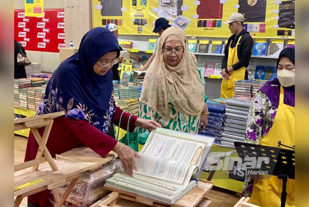 Pengunjung memeriksa senaskah al-Quran di Jualan Gudang Karangkraf di Kompleks Kumpulan Karangkraf pada Ahad.