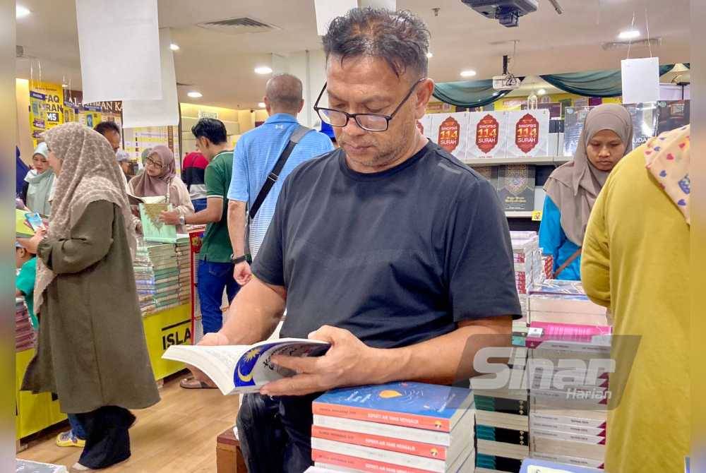 Pengunjung membaca buku di Jualan Gudang Karangkraf di Kompleks Kumpulan Karangkraf pada Ahad.