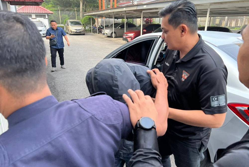 Inspektor (tengah) dikawal ketat polis ketika tiba di mahkamah.