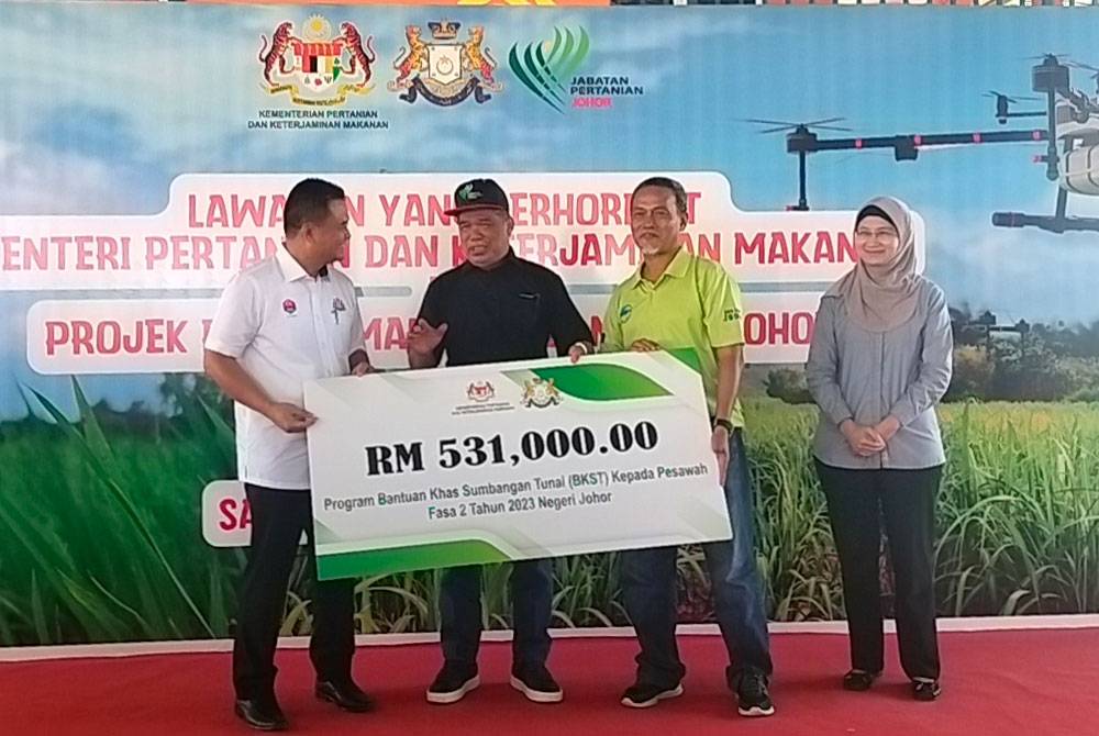 Mohamad (dua dari kanan) menyampaikan insentif kepada pesawah di Sawah Ring, pada Isnin.