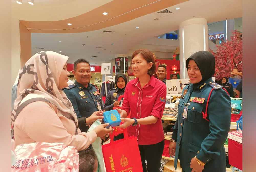 Sayani (kanan) dan Sandrea menyantuni orang ramai mengenai kesedaran bahaya kebakaran dalam Kempen Menghapus Bahaya Kebakaran dan Kempen Keselamatan Kebakaran sempena Tahun Baharu Cina 2024 di Pasar raya AEON Klebang dekat Chemor pada Isnin.