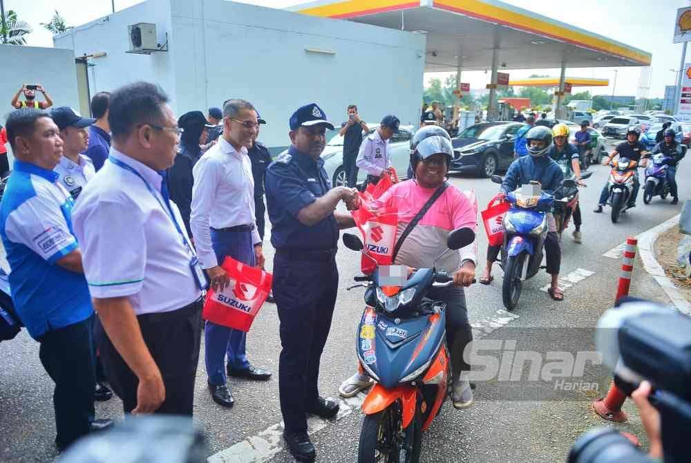 Hussein menyerahkan cenderahati kepada pengguna jalan raya selepas sempena Kempen dan Advokasi Keselamatan Jalan Raya Sempena Tahun Baru Cina 2024 di Plaza Tol Puchong Selatan, pada Isnin. Foto Sinar Harian-ASRIL ASWANDI SHUKOR