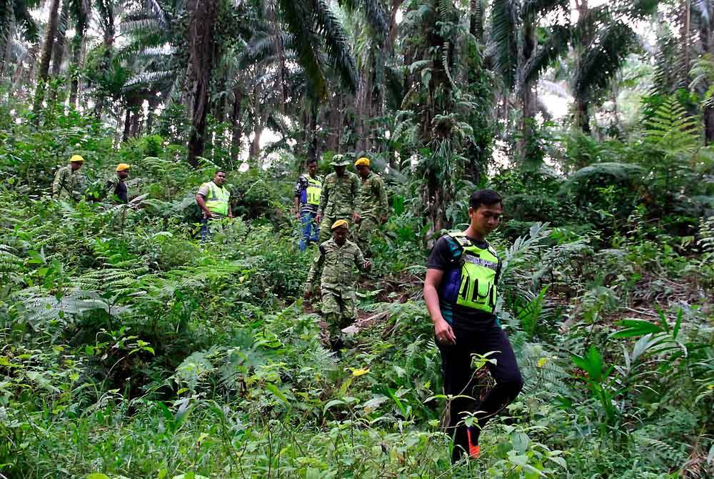 Anggota polis bersama anggota Jabatan Sukarelawan meneruskan operasi mencari tahanan yang lolos dari Depot Imigresen Sementara Bidor, di dalam kawasan hutan Kampung Sungai Kenoh, Tapah. Foto fail Bernama