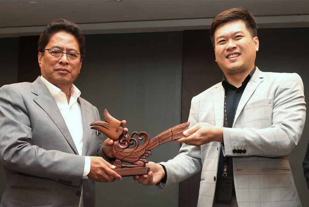 Azam Baki (kiri) menerima cenderamata daripada Presiden KDJA Ronnie Teo ketika hadir pada program Cakna Rasuah: SPRM Bersama Media hari ini. Foto Bernama