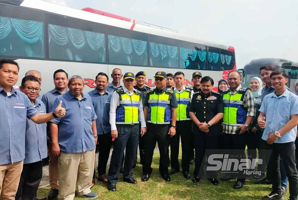 Lokman (depan, empat dari kanan) bergambar kenangan bersama kakitangan Transnasional selepas melakukan pemeriksaan bas di Depoh Transnasional, Sungai Chua, Kajang, Selangor sempena Ops JPJ Depoh Khas Bulan Perayaan.