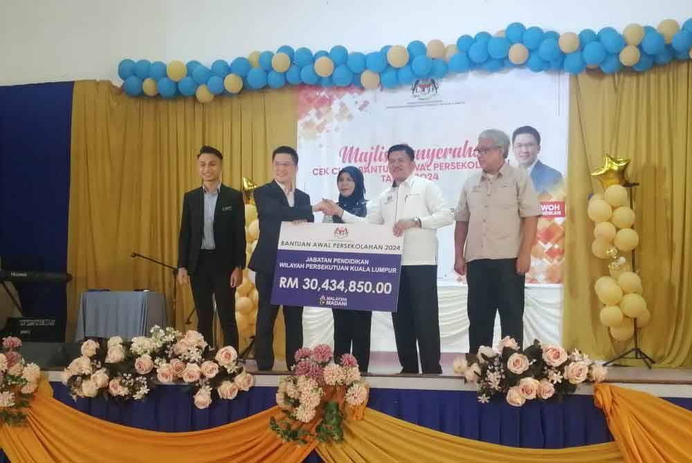 Kah Woh (dua dari kiri) pada Penyerahan Cek Cura Bantuan Awal Persekolahan Tahun 2024 peringkat WPKL di Sekolah Kebangsaan St Mary di Taman Intan Baiduri pada Rabu.