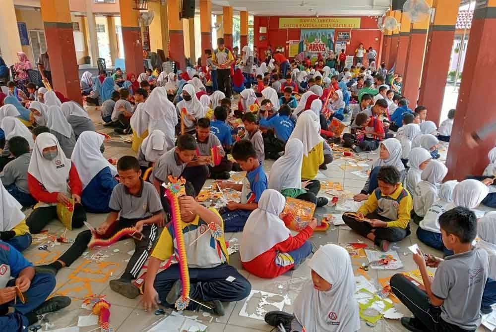 Murid sekolah menunjukkan kreativiti mereka menghasilkan origami kraf naga.