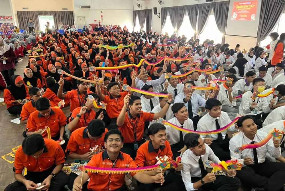 Pelajar sekolah menunjukkan origami kraf naga yang dihasilkan sempena ‘The Most 