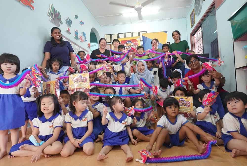 Siti Hawa (tengah) bersama kanak-kanak menunjukkan origami yang dihasilkan.