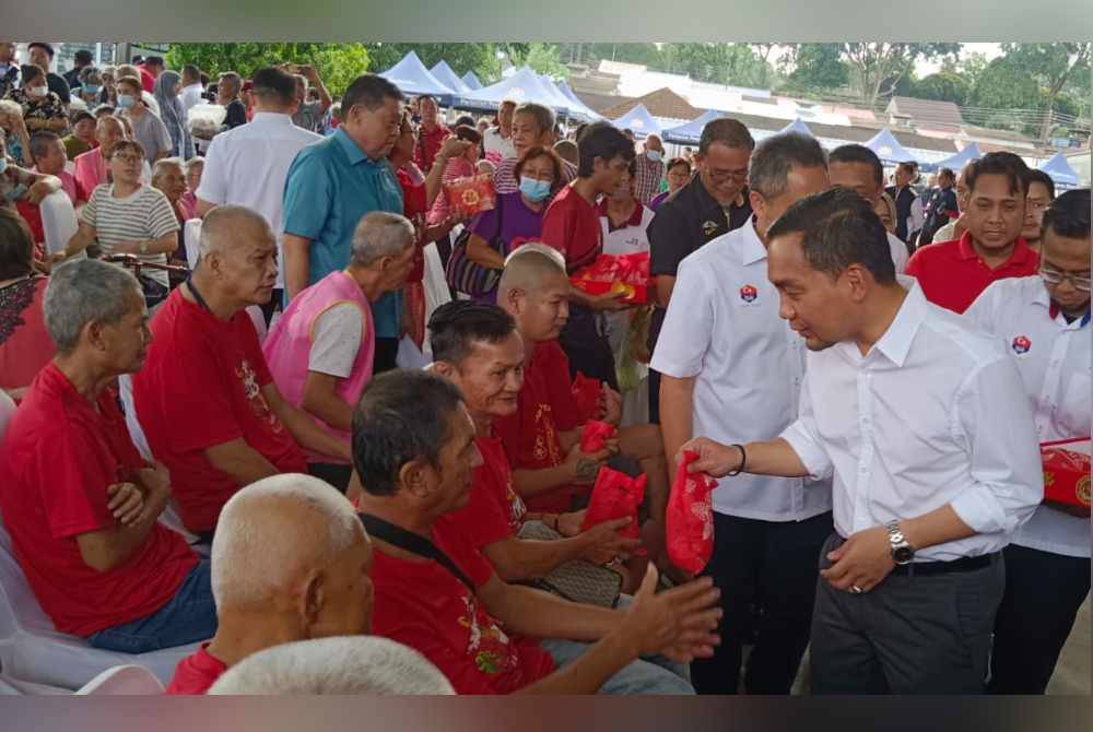 Onn Hafiz beramah mesra dan menyampaikan sumbangan kepada penerima dalam Majlis Pelancaran Jualan Kasih Johor sempena Tahun Baharu Cina di Taman Johor, Johor Bahru pada Rabu.