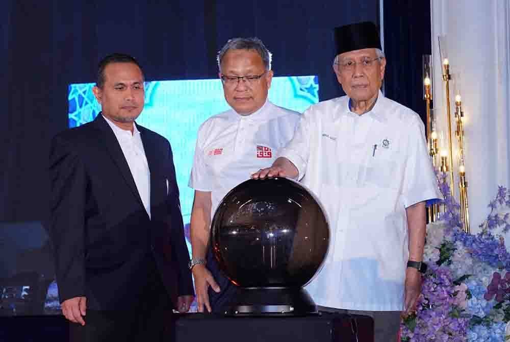 Abdul Aziz (kanan) bersama Ibrahim (tengah) sewaktu gimik pelancaran tabung Wakaf Tunai pada Rabu