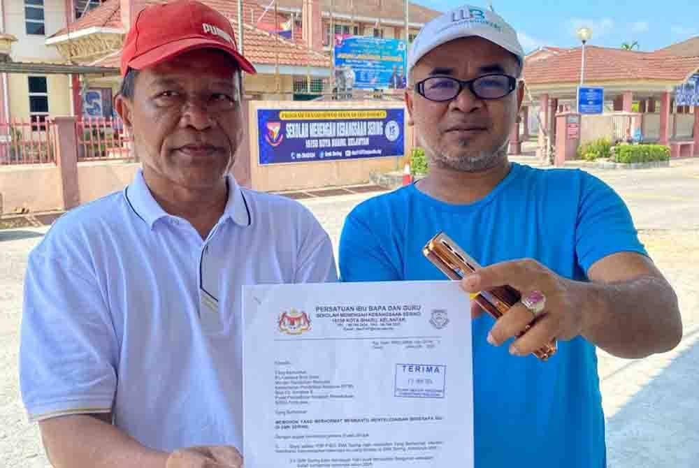 Sukri (kiri) menunjukkan surat yang dikirimkan kepada KPM memaklumkan situasi tersebut.