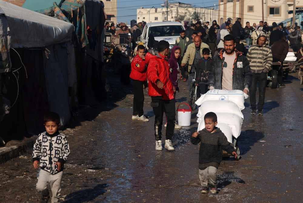 Penduduk Gaza menerima bekalan tepung diagihkan agensi bantuan di selatan Gaza.