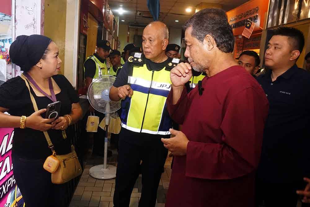 Dzowahir (kanan) dan Aman Shah (tengah) beramah mesra dengan orang awam pada Program Jelajah Mesra Exco Pengangkutan Kedah di Terminal Bas Shahab Perdana, di sini, pada malam Khamis.