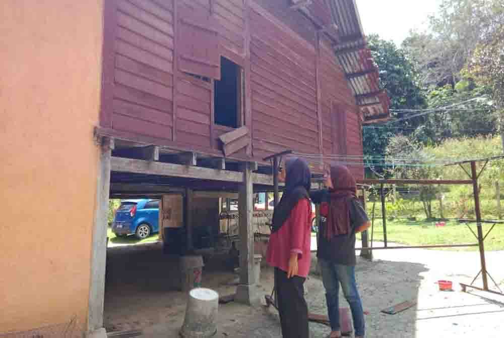 Norhayati (kanan) bersama seorang lagi ibu saudaranya, Normah Ahmad, 60 menunjukkan lokasi papan yang dipercayai diumpil penyamun terbabit