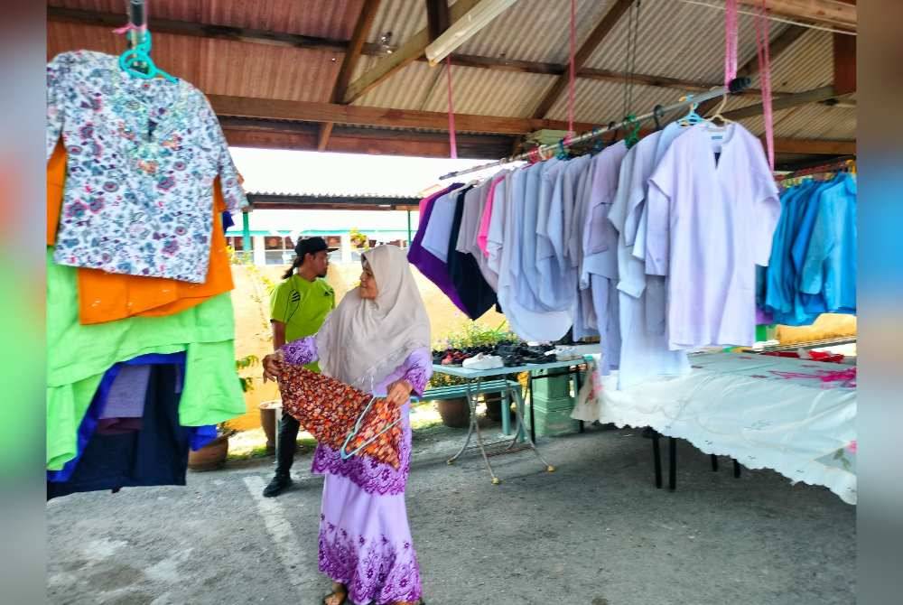 Seorang jawatankuasa masjid menyusun pakaian terpakai yang disumbangkan orang ramai.