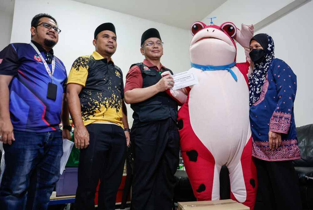 Mohd Na'im (tiga, kiri) menyampaikan sumbangan Bantuan Kecemasan MAIWP kepada Mohamad Salman Abdullah, 23, (dua, kanan) dan ibunya Saniah Taib, 54, pada Program Ziarah malam ini. Foto Bernama