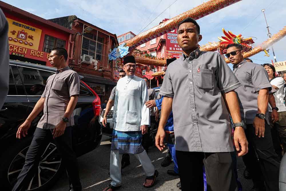 Anwar meninjau kawasan sekitar Banda Hilir ketika sesi Tinjauan Mesra dan beramah mesra bersama para penjaja kecil di Car Free Zone, Banda Hilir pada Jumaat - Foto Bernama