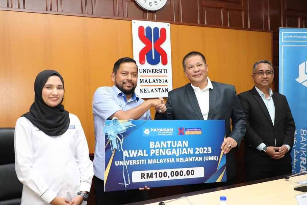 Menyerahkan replika cek sumbangan kepada Razli (dua dari kanan) di UMK Bachok pada Jumaat.