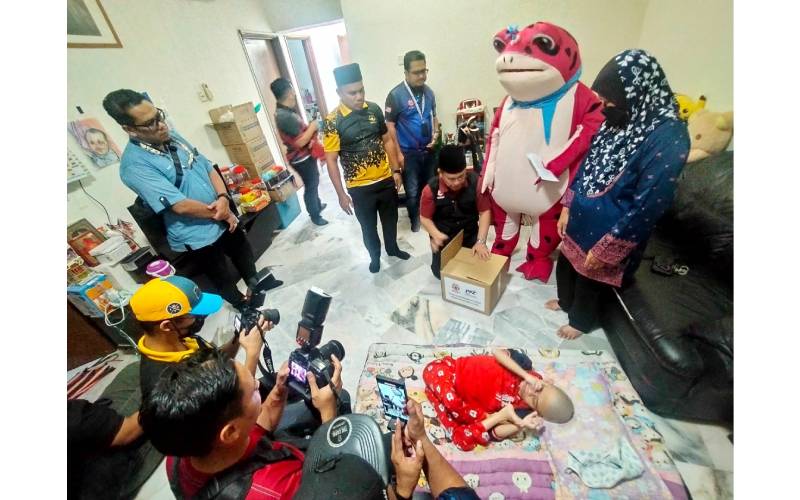 Mohd Na’im (duduk) memeriksa kotak bantuan MAIWP untuk diserahkan kepada keluarga Salman.