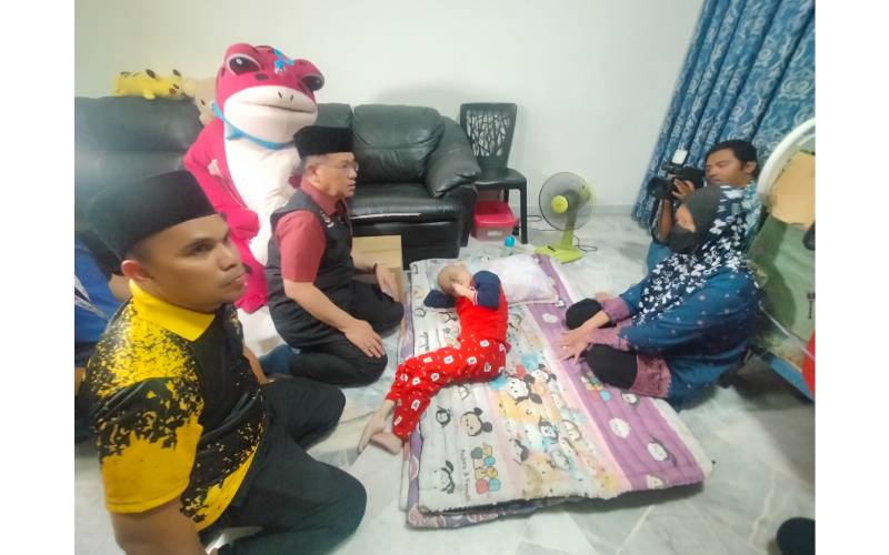 Mohd Na'im (dua dari kiri) bertanyakan keadaan Siti Norashikin yang terlantar ketika menziarahi kediaman mereka di Menara Putra pada Khamis.