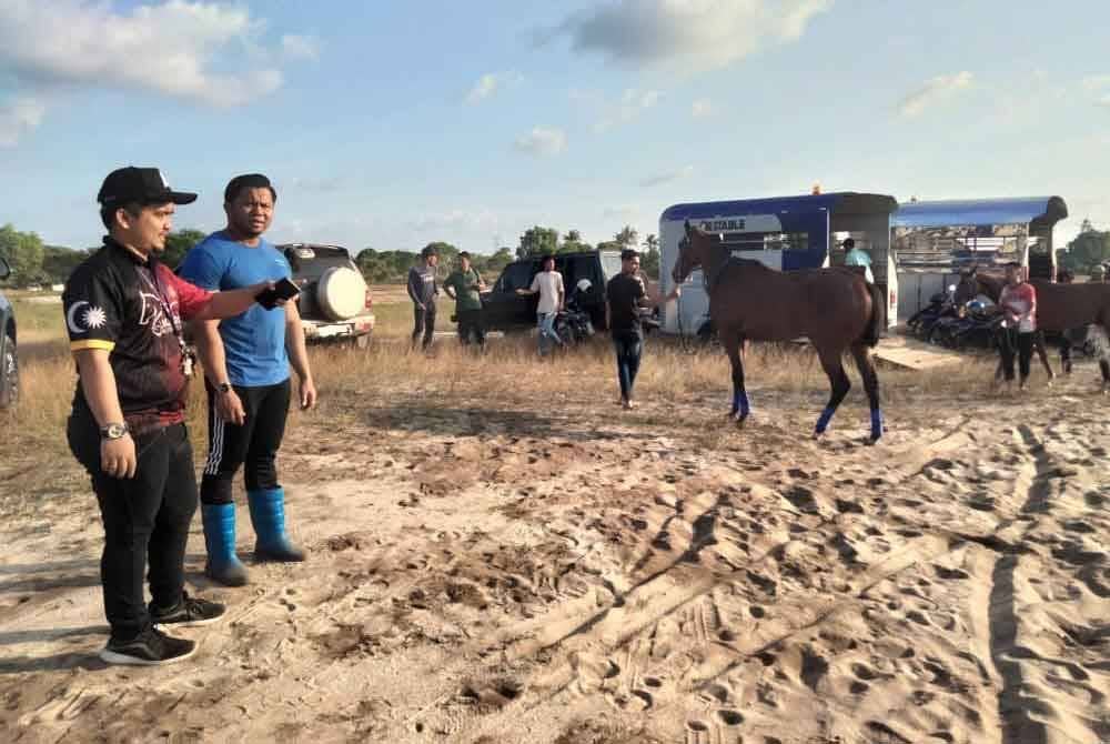 Mohd Faris (kiri) bersama seorang pemilik kuda yang menyertai Sukan Berkuda Kampung Padang Bual Siri 1 2024.