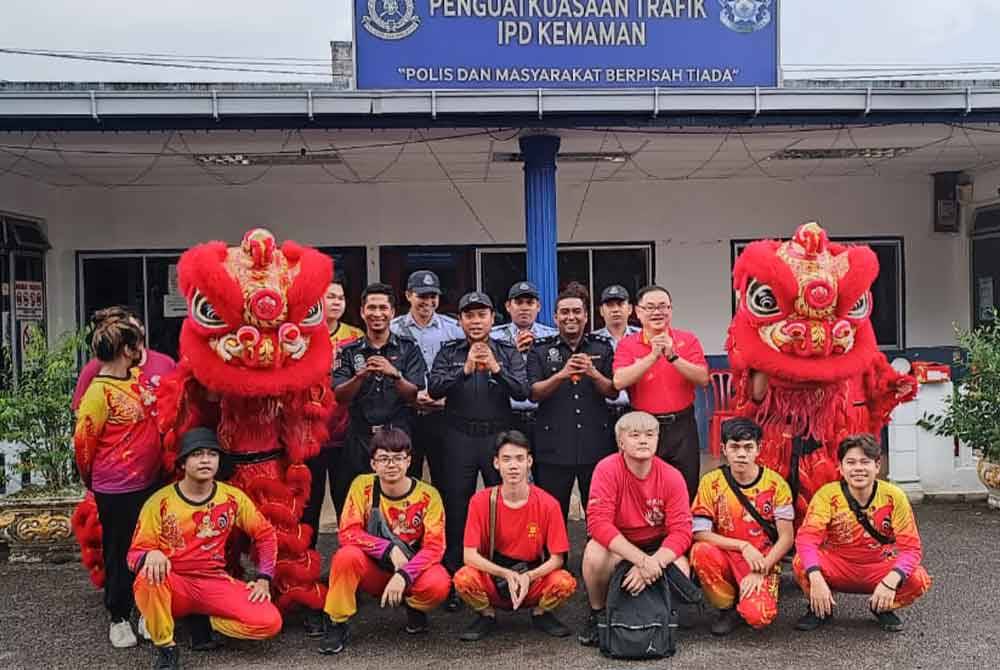 Zul Ilham (berdiri dua dari kiri) bersama Mohamad Ramizan Ramli (berdiri dua dari kanan) dan Ketua Unit Kebajikan Kelab Kemaman, Tan Kwang Ming (kanan) merakam gambar selepas pertunjukan tarian naga di BSPT IPD Kemaman pada Sabtu.