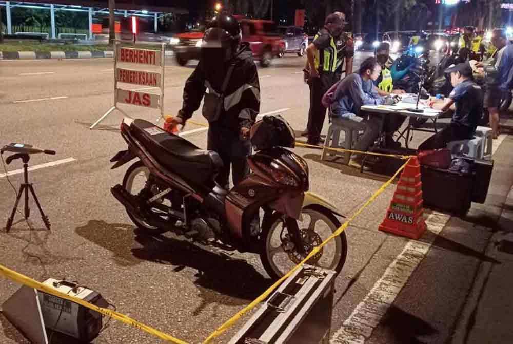 Sebuah motosikal melakukan pemeriksaan JAS semasa operasi polis di ibu negara pada Sabtu.