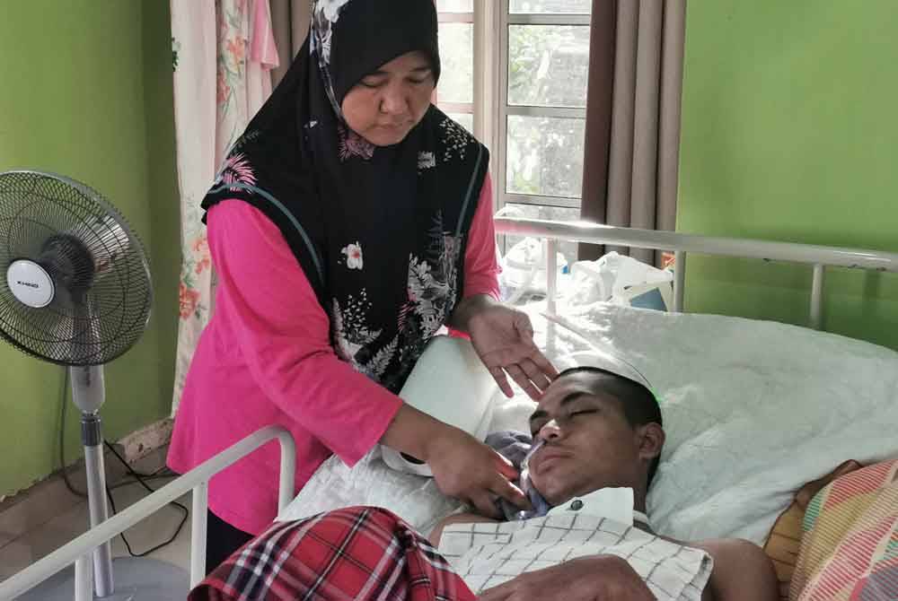Wan Murni merapikan Muhammad Amirul Nazmi ketika ditemui pemberita di Kampung Jaba, Bukit Apit, Ajil di Hulu Terengganu.