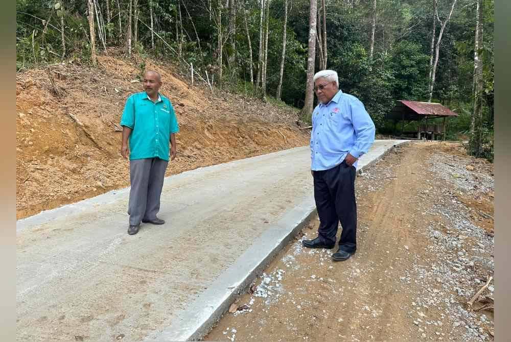
Abdul Hadi (kanan) dan Wan Azman (kiri) berada di jalan konkrit yang dibina di Kampung Seberang Janggut.