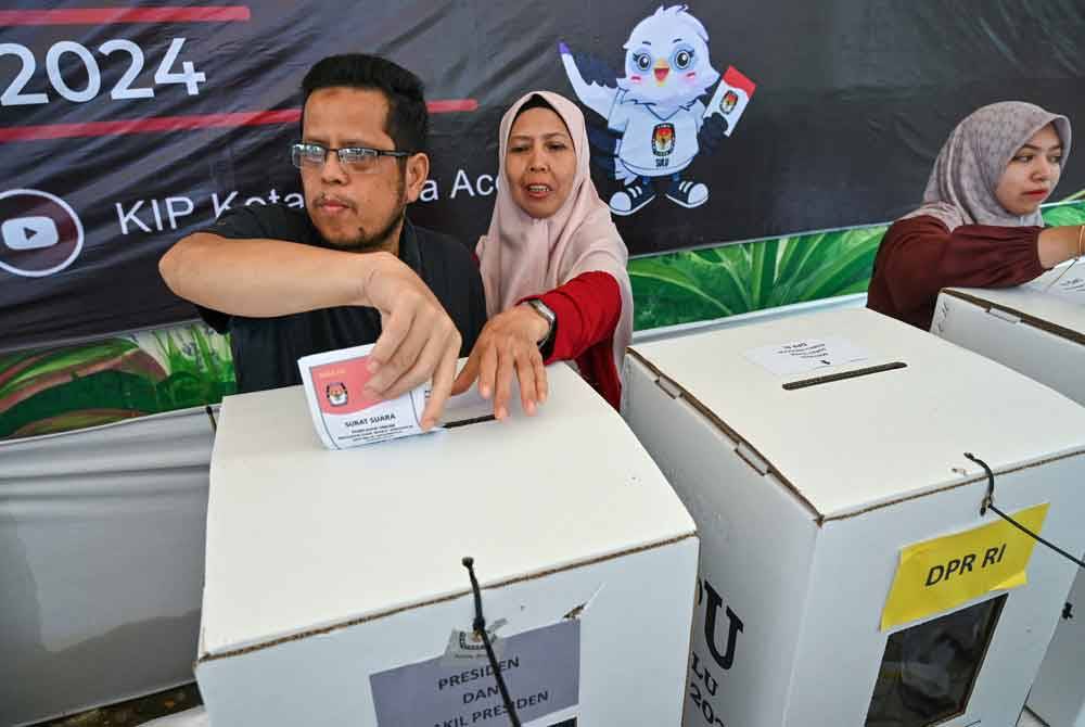 Seorang lelaki membuang undi ketika latihan proses pengundian
di Banda Aceh pada bulan lalu.
