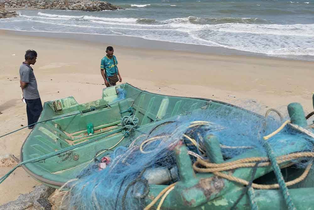 Zawawi (kiri) bersama Mohd Syukri (kanan) ketika ditemui pemberita sewaktu melihat bot yang rosak berhampiran jambatan angkat di Kuala Nerus.