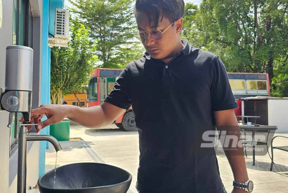 Syafiq menunjukkan gangguan bekalan air yang menjejaskan pengoperasian hotelnya di Teluk Dalam, Pulau Pangkor.