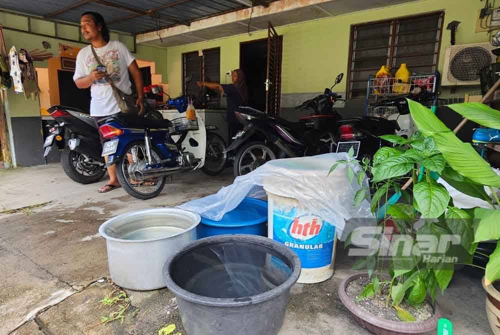 Besen dan tong diletakkan di hadapan rumah untuk mengisi bekalan air dari lori tangki LAP.