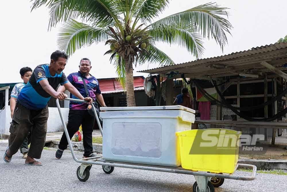 Seorang penduduk Kampung Teluk Dalam, Pulau Pangkor menggunakan troli untuk mengangkut bekalan air yang diperoleh daripada lori tangki LAP.
