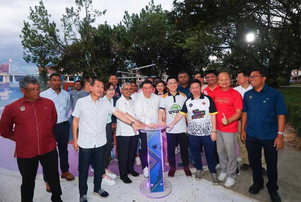 Kor Ming (tengah) menyempurnakan gimik perasmian pembangunan landskap persekitaran kehidupan di Taman Woodland dekat Bandar Baru Tambun pada Selasa.