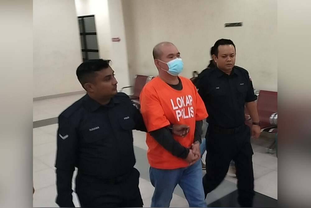 Tertuduh diiringi polis selepas dihadapkan di Mahkamah Majistret, Muar pada Rabu.
